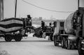 Construction worker stands on a concrete mixer on a black and white photo