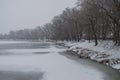 Winter day. River frozen - covered with ice and naked trees covered with white snow on there branches. Walking on nature