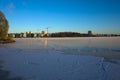 Winter day in Scandinavia, Frost covered ice of frozen lake Malaren, view of construction cranes in new residential area