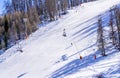 Winter day on a ski resort in Europe. Beautiful texture created by skiers descending the mountain. Ski lift on the slop Royalty Free Stock Photo