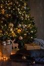 Winter decor: Christmas tree,garland, balls, gifts and cozy striped and gray plaids with pillows. Selected focus