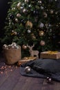 Winter decor: Christmas tree,garland, balls, gifts and cozy striped and gray plaids with pillows