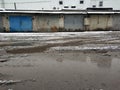 Winter dirty broken road in a garage cooperative. Gray depressing moody winter Royalty Free Stock Photo