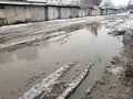 Winter dirty broken road in a garage cooperative. Gray depressing moody winter Royalty Free Stock Photo