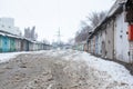 Winter dirty broken road in a garage cooperative. Gray depressing moody winter Royalty Free Stock Photo