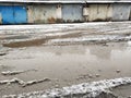 Winter dirty broken road in a garage cooperative. Gray depressing moody winter Royalty Free Stock Photo