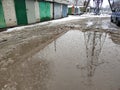 Winter dirty broken road in a garage cooperative. Gray depressing moody winter Royalty Free Stock Photo