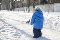 Winter dressed boy walking on a snowy street