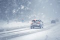 Winter drive car enveloped in snow during a snowstorm