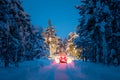 Winter Driving - Lights of car and winter road in night forest Royalty Free Stock Photo