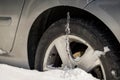 Winter driving problems, snow and ice. Extreme winter series. Huge icicles on the dirty car wheel. Dangerous ice build up car