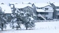 Winter Embraces Suburban Homes with Gentle Snowfall and Serene Skies