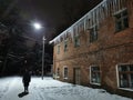 winter evening icicles hanging from the roof in the light of a lantern Royalty Free Stock Photo