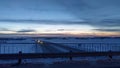 Winter evening and sunset over the plain, where the highway is laid and cars move along it