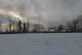 Winter evening in the village. The sun sets, clouds, cold, frost. dark.