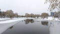 In winter everything is covered with snow, and the water channel in the city park is partially covered with ice. Willows and birch Royalty Free Stock Photo