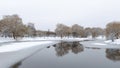 In winter everything is covered with snow and the water channel in the city park is partially covered with ice. The willows are re Royalty Free Stock Photo