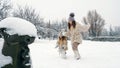 winter family activity outdoors. side view. Happy little girls, children are slowly walking through thick snow in the Royalty Free Stock Photo