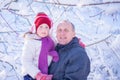A man and a little girl are smiling cheerfully against the background of a snow-covered forest. Winter family portrait of Royalty Free Stock Photo