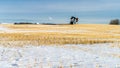 Winter farm field with oil pumpjack Royalty Free Stock Photo