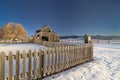 Winter farm with wood fence and barn and snow on the ground