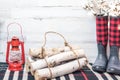 Winter farmhouse background with boots, logs and lantern Royalty Free Stock Photo