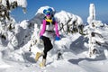 Winter fashion. Beautiful woman is wearing silver jacket, ski goggles and colorful beanie and scarf. Mountain climbing. Szrenica,