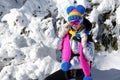 Winter fashion. Beautiful woman is wearing silver jacket, ski goggles and colorful beanie and scarf. Mountain climbing. Szrenica,