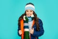 winter fashion. emotional kid with curly hair in hat and scarf. teen girl in puffer jacket