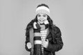 winter fashion. emotional kid with curly hair in hat and scarf. teen girl in puffer jacket