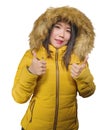 Winter fashion isolated portrait of young beautiful and happy Asian Korean woman in warm yellow feather jacket with fur hood Royalty Free Stock Photo