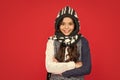 winter fashion. positive kid with curly hair in knitwear. teen girl on red background.