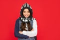 winter fashion. positive kid with curly hair in knitwear. teen girl on red background.