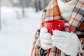 Winter female hand holding a red Cup. Royalty Free Stock Photo