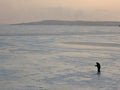 A winter fisherman on ice is fishing