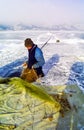 Winter fishing on the ice of Baikal. Fishermen are engaged in wi Royalty Free Stock Photo