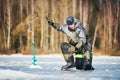 Winter fishing on ice. Fisherman hooking fish. Biting Royalty Free Stock Photo