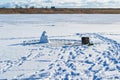 Winter fishing. Fishing from the ice. Homunculus loxodontus sculpted from snow on a winter fishing trip. Royalty Free Stock Photo