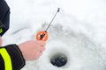 Winter fishing on ice. Jiggling bait in an ice hole. Relaxing in the wild Royalty Free Stock Photo