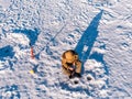Winter fishing on ice, top aerial view, fisherman rod in hole in lake