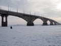 Winter fishing on the ice. The Volga river in Saratov, Russia. Road bridge on the horizon