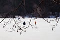 Winter fishing. River, lake near forest in ice. Blurred image of Anglers, Fishermens through tree branches, favorite men Royalty Free Stock Photo