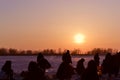 Winter fishing at sunset, silhouettes of fishermen Royalty Free Stock Photo