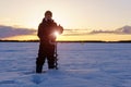 young man millennial fishing early in the morning on a winter lake. Winter sports Royalty Free Stock Photo