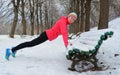 Winter fitness and running in park: happy woman runner warming up and exercising before jogging in snow Royalty Free Stock Photo