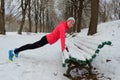 Winter fitness and running in park: happy woman runner warming up and exercising before jogging in snow Royalty Free Stock Photo