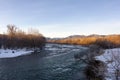 A frosty winter morning on a mountain river, the rays of the rising sun illuminate the panorama of the mountainous area. Royalty Free Stock Photo