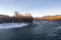 A frosty winter morning on a mountain river, the rays of the rising sun illuminate the panorama of the mountainous area. Royalty Free Stock Photo