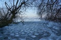 Winter forest with amazing river at sunset. Winter landscape with snowy trees, ice, beautiful frozen river, snowy bushes, colorful Royalty Free Stock Photo