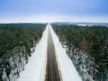 Winter forest and asphalt road. View from above. The photo was taken with a drone. Pine and spruce forest with a black road in the Royalty Free Stock Photo
